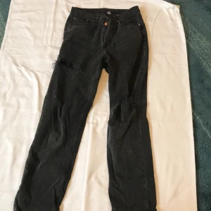 Svarta ripped jeans  - - Plagg: Jeans  - Mönster: Ripped  - Färg: Washed out svart - Storlek: US = 8 - Märke: Divided, H&M - Skick: Väldigt Bra  - Egenskaper: Straight, Washed out, hög-mid waist, ripped, många knappar (ingen dragkedja)  Kontakta mig gärna vid frågor 💕 
