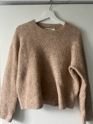 Stickad beige tröja - Stickad tröja från Carin Wester. Har krympt i tvätten så passar numera en S/ liten M 