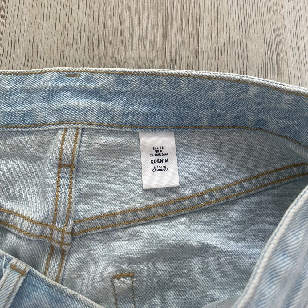 Blå denim jeanskjol från H&M, slitningar på låret, knappt använd . Kjolar.