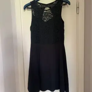 En jättefin svart klänning med spets och lite öppet vid ryggen. Väldigt skön! Använd men är i väldigt fint skick. 