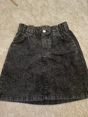 Svart jeanskjol - Vacker svart jeanskjol, använd 2 ggr. Tvättas innan skick. Är i storlek xs men fungerar till 146 och 152