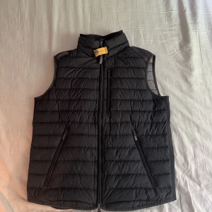 Parajumpers väst strl. S - Parajumper väst i storlek S. Condition 7/10 då det är ett litet hål i fram men det syns inte vid användning. Det är även en fläck på innefickan men den syns inte heller.  Västen är äkta och köpt på Pondus för ungefär ett år sedan. 
