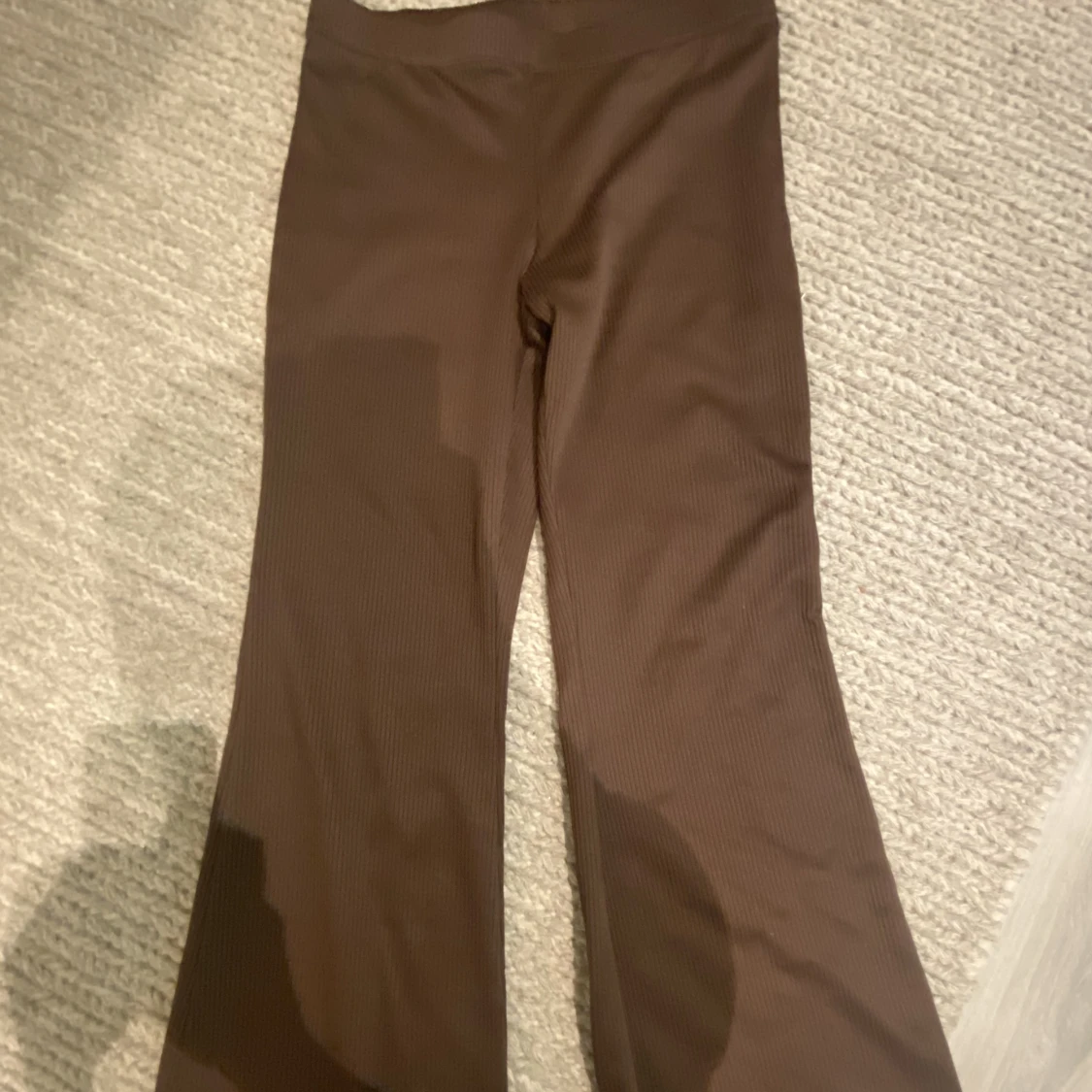 Bruna utsvängda byxor.