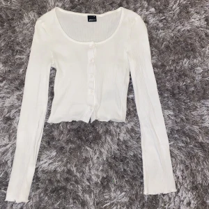 Vit långärmad  - Denna vita tröjan kommer ifrån Gina. Tröjan är cropad och i nyskick💕
