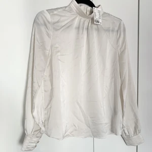 H&M Blus - Office Wear!🌟 - Naturvit blus från H&M med guldfärgade knappar i nacke och handleder. Aldrig använd, prislapp kvar, nypris 249kr.