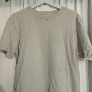 Beige T-shirt Uniqlo - Beige T-shirt från Uniqlo. Köpt second hand. Storlek S men passar M också. 