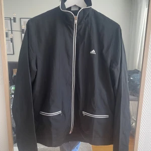 Vindjacka adidas - Vindjacka från adidas, köpt för många år sen men har mest hängt i garderoben. Skick 10/10 skulle jag säga. Tunn men vindtålig! 