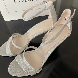 Tiamo Klackskor - Säljer dessa silver/glittriga klackskor köpta från Tiamo förra året. ENDAST ANVÄNDA EN GÅNG, och därav i väldigt bra skick. Storlek 41. Har 9 cm klack.  Orginalpriset är 699kr, men säljs nu för 499. Har både möjlighet till att mötas upp samt posta. 💘🌸🫶🏼