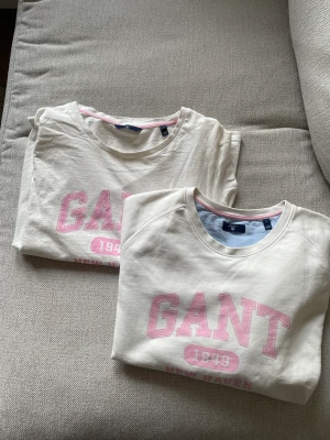 Vit gant t-shirt och gant sweatshirt med rosa tryck - Måttligt använda ganttröjor i fint skick.  Båda tröjorna är i stl L, men skulle jämföra den lite mer åt en M. Båda tröjorna kommer i ett paketpris på 300kr 