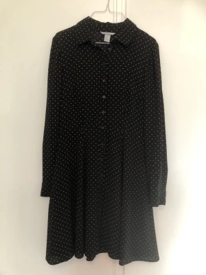 Svart mesh klänning med orange prickar - Klänning med meshtyg, svart med orange prickar. Storlek 36 men passar 38.  Kan mötas i centrala stockholm eller skickas mot frakt 