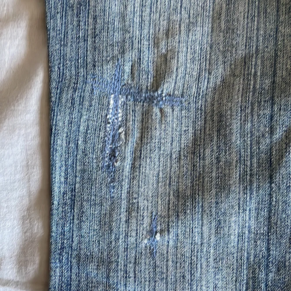 Mid waist jeans i S/M  midjemått: ca 90cm de är lite trasiga på baksidan långt ned på låret men det är sytt igen (se sista bild) därav ser det ut som ett litet kors. Jeans & Byxor.