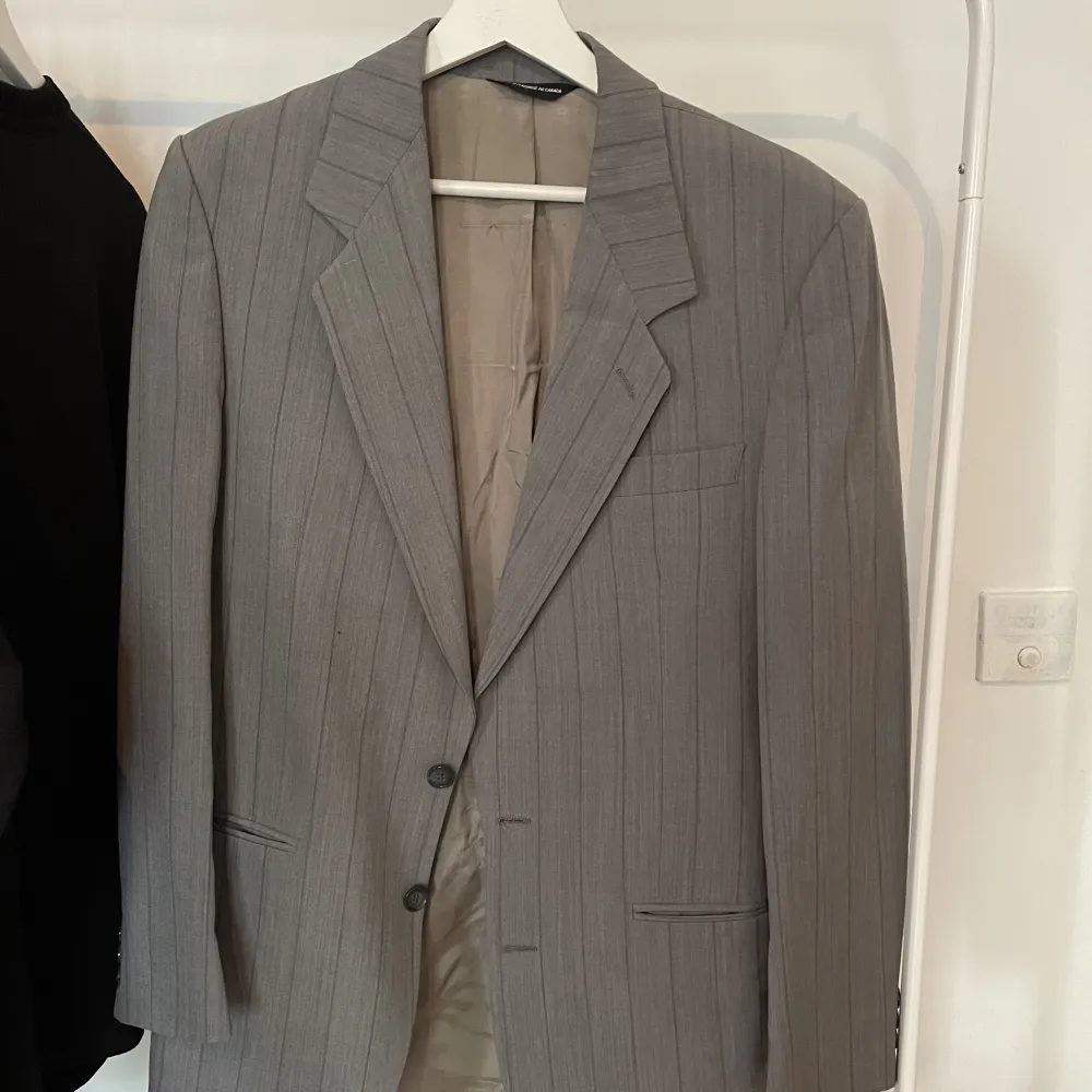An oversized gray blazer with shoulder pads. Perfect for every occasion for a touch of classiness or dramticness.  Like a size L/ XL for women, a size M/ L for men.. Kostymer.