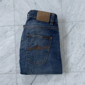 Nudie Jeans ’Grim Tim’ - Säljer nu dessa feta Nudie Jeans i den eftertraktade modellen ’Grim Tim’ som har en slim-fit passform. Jeansen är i kanon skick utan några defekter - Nypris: 1800 kr - Storlek: 30/34 - Hör av er vid minsta fråga eller fundering :)
