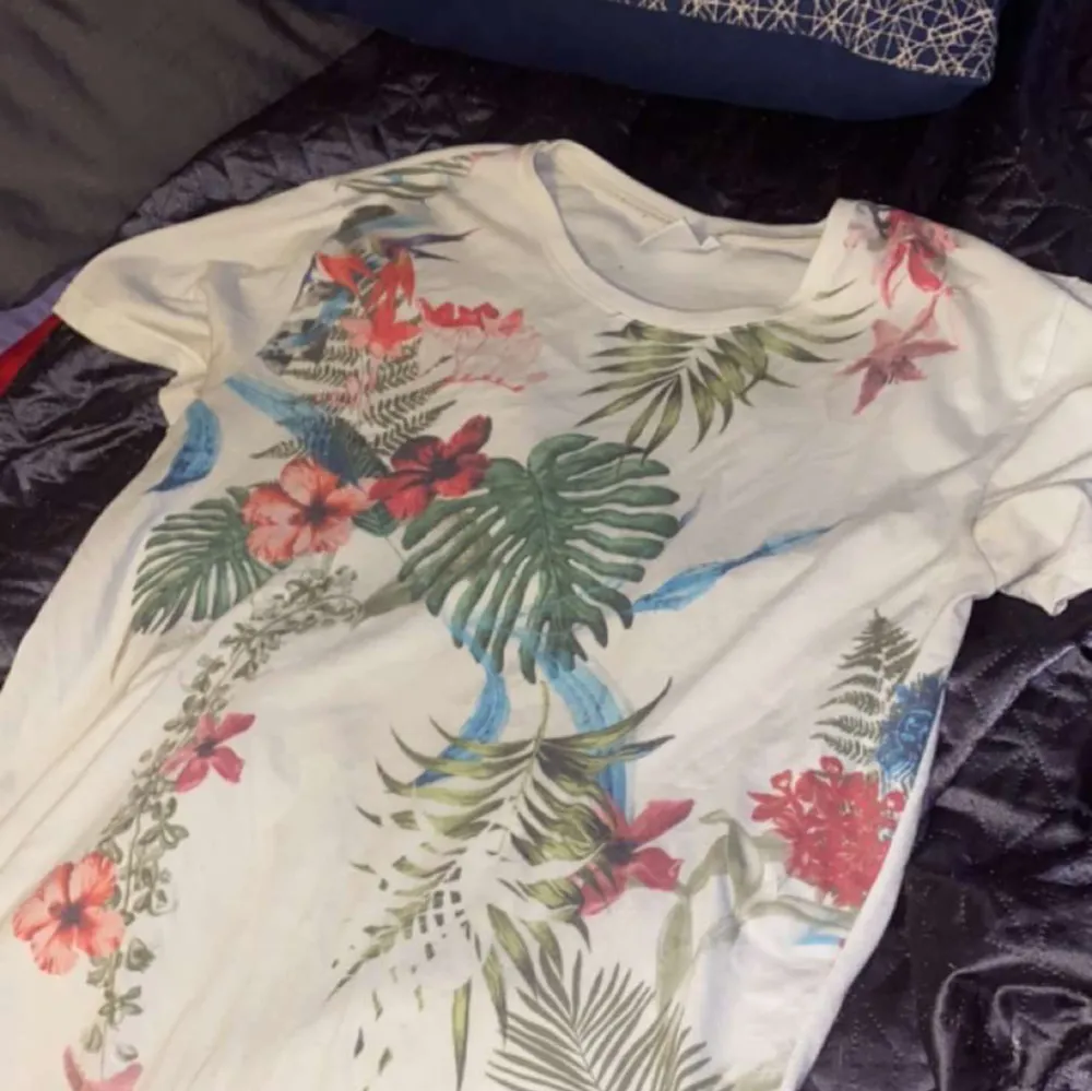 En vanlig T-shirt med ett guld tryck av blommor och växter på. Den är i ett perfekt skick och nästa helt ny. . T-shirts.