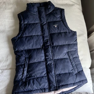 GANT-väst - SKITSNYGG väst i marinblå från Gant, så skön, passar till allt och perfekt nu till hösten!! Jättefin färg med rosa insida, nyskick!! Är för barn men passar mig som vanligtvis har S/M