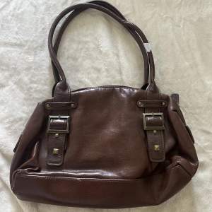 En jättefin liten vintage väska i brun färg. Passar perfekt under axeln. 