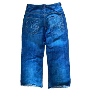 Vintage 00s Baggy G-Unit Jeans - Vintage baggy G-Unit jeans från 2000-talet med broderi på bakfickorna. Jeansen är i bra skick men klippta där nere som man kan se på bilderna. Känn dig fri att fråga om du undrar något!