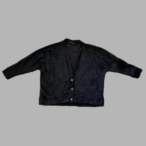 Mysig svart kofta  - Säljer min svarta kofta med lite fluffigt tyg. Påminner lite om en från Our Legacys äldre kollektioner. Jättefin med skjorta eller t-shirt under. Säljer pga för tajt i armarna på mig. 68% akryl 32% polyamid. Jag 