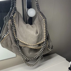 Stella McCartney väska  - Säljer min Stella McCartney väska för den inte kommer till användning längre.  Haft den ett tag så det syns att den är använd men annars väldigt bra skick🩷 Priset kan diskuteras  Nypris ca 9000kr  Skriv för fler bilder 