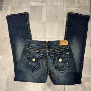 True religion jeans  - Säljer dessa supercoola lågmidjade true religion bootcut jeansen! De har coola gula detaljer! Tyvärr var de för små för mig. Midjemått 35cm, innerbenslängd 69 cm❤️‍🔥