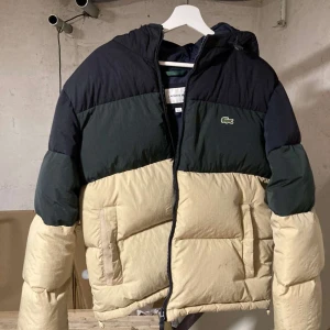 Lacoste Jacka - Har använt den en vinter å den är jätte varm å väldigt fluffig, har en väldigt snygg passform på kroppen. Storlek M