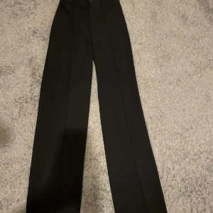 Kostymbyxor  - Svarta figursydda byxor med raka ben. Hög midja och stråveck. Sköna att gå i. Aldrig använts. Köpt för 369kr.