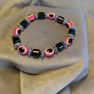 Armband oanvänt Onesize rosa och silvrigt - Armband oanvänt Onesize rosa och silvrigt  Fint skick då det är oanvänt  Ligger i påsen som den köptes i Troligtvis köpt i Grekland  Vikt 16 gram 