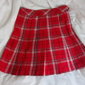 En rödrutig kjol som ger lite skol uniforms vibes. Storlek 32, high-waisted mini skirt, knappt använd.