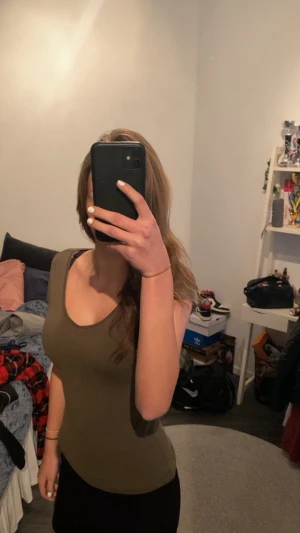 Olivgrön tight tröja  - En tight olivgrön tshirt som är stretchig. Är en storlek S i vanliga fall och den här är storlek 34. Passar de som har från xs till m skulle jag säga. Aldrig använd men thriftad 