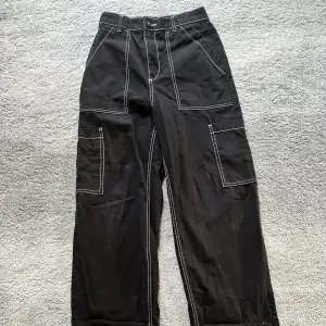Baggy cargo-jeans. Svarta med vita sömmar.  Storlek 34.