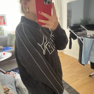 Puma hoodie - Feeet puma sip-up med tryck över bröstet. Cool som fan, har aldrig sätt liknande. Svart med vita detaljer, superfin!