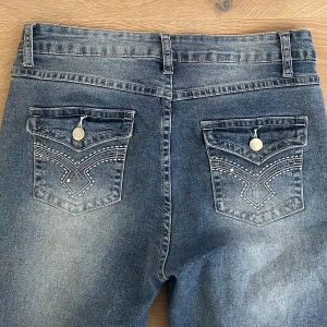 Jeans med coola fickor  - Säljer dessa low rise bootcut jeansen med coola detaljerade fickor. De är köpta second hand på Björk & frihet i Malmö och saknar lapp, därför står inget specifikt märke. ca 78cm i midjan och 110 innerbenslängd! 