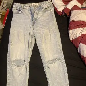 Strandivarius jeans i bra skick. Fabrikshål på båda knäna, ett litet hål strax ovanför högerknä och vänster bakficka. ”Franskant” längst ner på byxorna. Storlek: 38 Säljs för att dom inte längre passar.