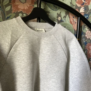 Grå tröja  - Ljusgrå melerad tröja med breda ärmar från Monki i tjockt material. Använd en gång så väldigt fint skick. Längd 43cm, bredd under ärmarna 51cm, 73cm från hals till ärmslut. 