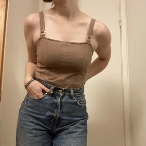 Brun Bodysuit - En brun bodysuit med snygga ”metallklammor” vid banden. Pris kan diskuteras 🙌