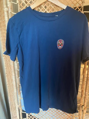 Suspicious Antwerp T-Shirt - Säljer en mörkblå t-shirt från Suspicious Antwerp i storlek M (Us)/L (EUR). Skulle att den är en mindre medium.