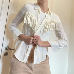 Cowboy skjorta  - Unik krämvit skjorta med cowboy fransar på i storlek 36 från & Other Stories 🤠Tycker den är så söt, säljes endast för den är för kort i mina ärmar 🥲