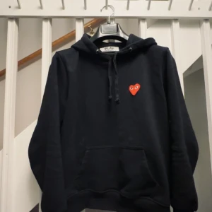 Comme des Garcons   play hoodie  - Tja! Säljer en riktigt snygg CDG hoodie i storlek Small (S). Skick 8/10. Säljer pågrund av att jag växt ur den. Ny pris 2195!. Vid fler frågor så skriv privat så svarar jag så fort som möjligt🤝🏽