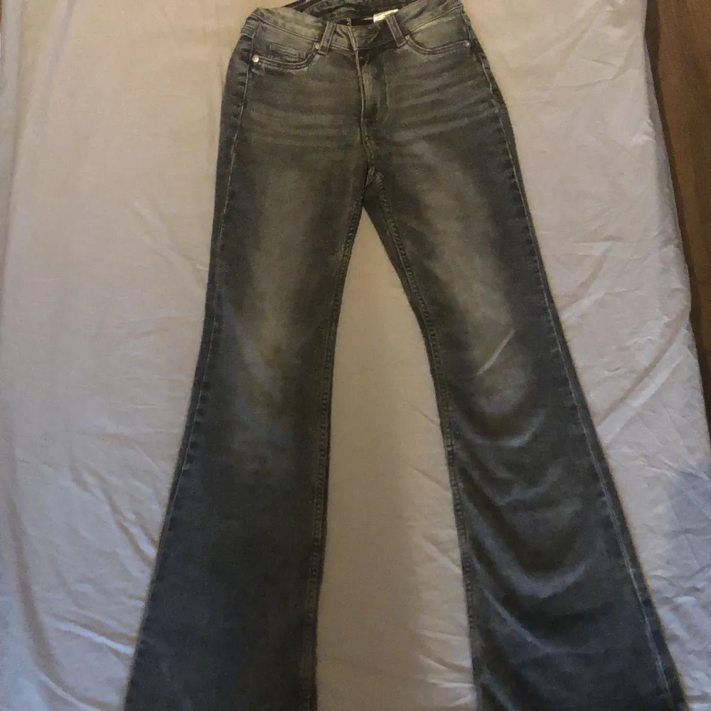 Gråa bootcut jeans från H&M Divided. Storlek 34. Bra skick. Säljer pågrund av att de är förstora.. Jeans & Byxor.