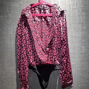 Body | FashionNova - En jättefin body med rosa mönster. Den är så fin tillsammans med svarta kostymbyxor till exempel! Men den kan stylas hur som helst. Från FashionNova i storlek Small. Skriv privat för mer info och bilder.