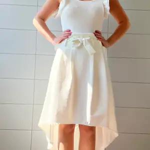 Jättesöt vit lång kjol, som är längre fram än bak, den har en liten fläck längst ut på snöret (se sista bild). Passar strl S