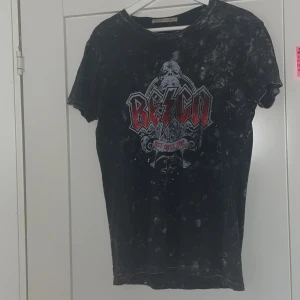 Svart t-shirt med tryck - En tröja ifrån någon butik inne i Stockholm city. Det står i tröjan ”Reign”. 