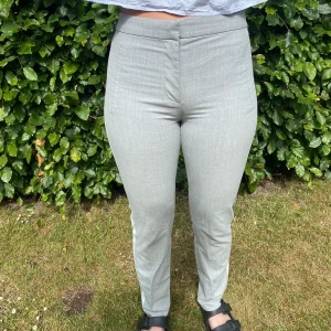 Gråa kostymbyxor - Gråa kostymbyxor från zara i storlek xs med vita sträck på sidorna.