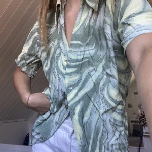 Grön mönstrad skjorta - 🥒mönstrad grön skjorta. Passar en storlek XS-M beroende på hur du vill ha passformen. Frakt tillkommer!