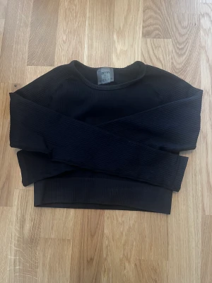 Aimn tröja  - En kroppad träningströja från aimn i stl S. Kortare i modellen och ribbat material, väldigt skön att träna i. Den kom inte till användning för mig, så väldigt fint skick. Nypris 549kr