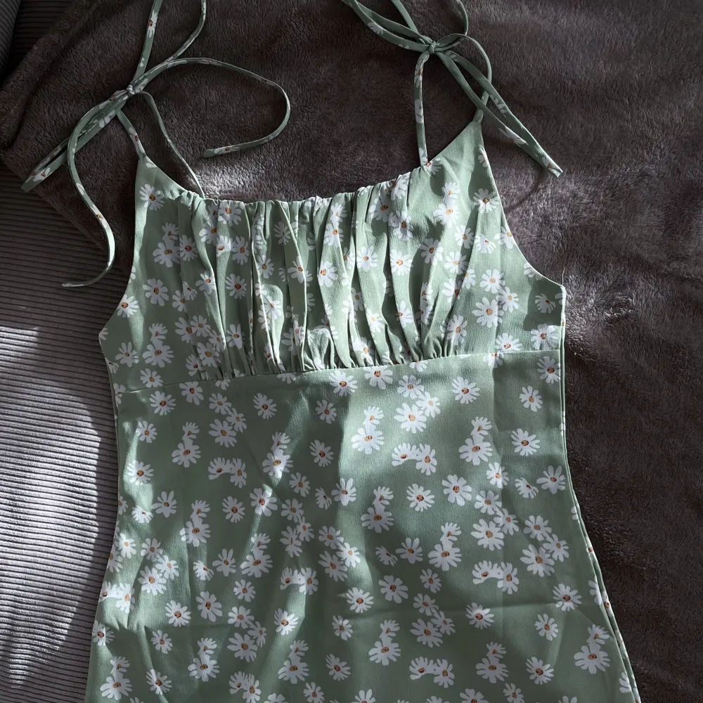 Grön blommig klänning med knytband över axlarna. Från en fransk butik, Outfitbook :) Superfin! Knappt använd då den inte passar 🤍. Klänningar.