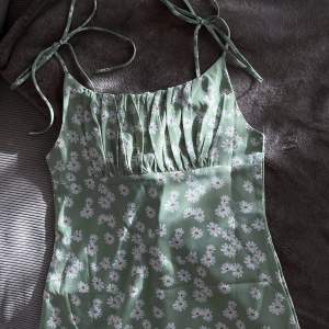 Grön blommig klänning med knytband över axlarna. Från en fransk butik, Outfitbook :) Superfin! Knappt använd då den inte passar 🤍