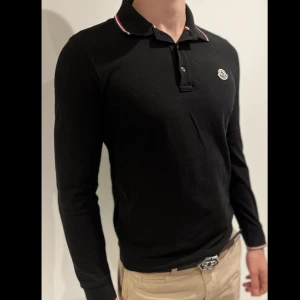 Moncler Långärmad Piké  - En långärmad svart klassisk moncler piké i storlek small. Den är true to size, i nyskick, och äkta.