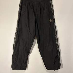 Stüssy Trackpants Färg: Svart Storlek: L (passar M)  Kön: Man Skick: Bra skick Material: 100% Polyester 