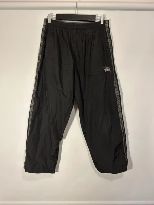 Stüssy Trackpants - Stüssy Trackpants Färg: Svart Storlek: L (passar M)  Kön: Man Skick: Bra skick Material: 100% Polyester 